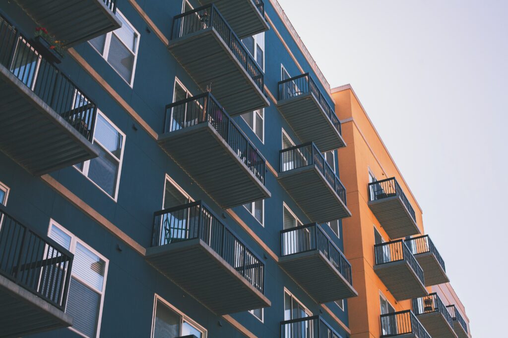 Modern home building with blue and orange facade and external balconies.