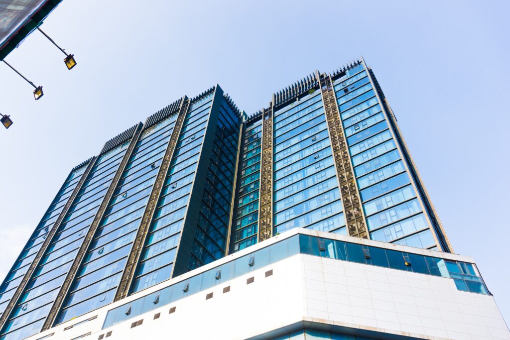 Modern glass skyscraper, a home against a clear blue sky.